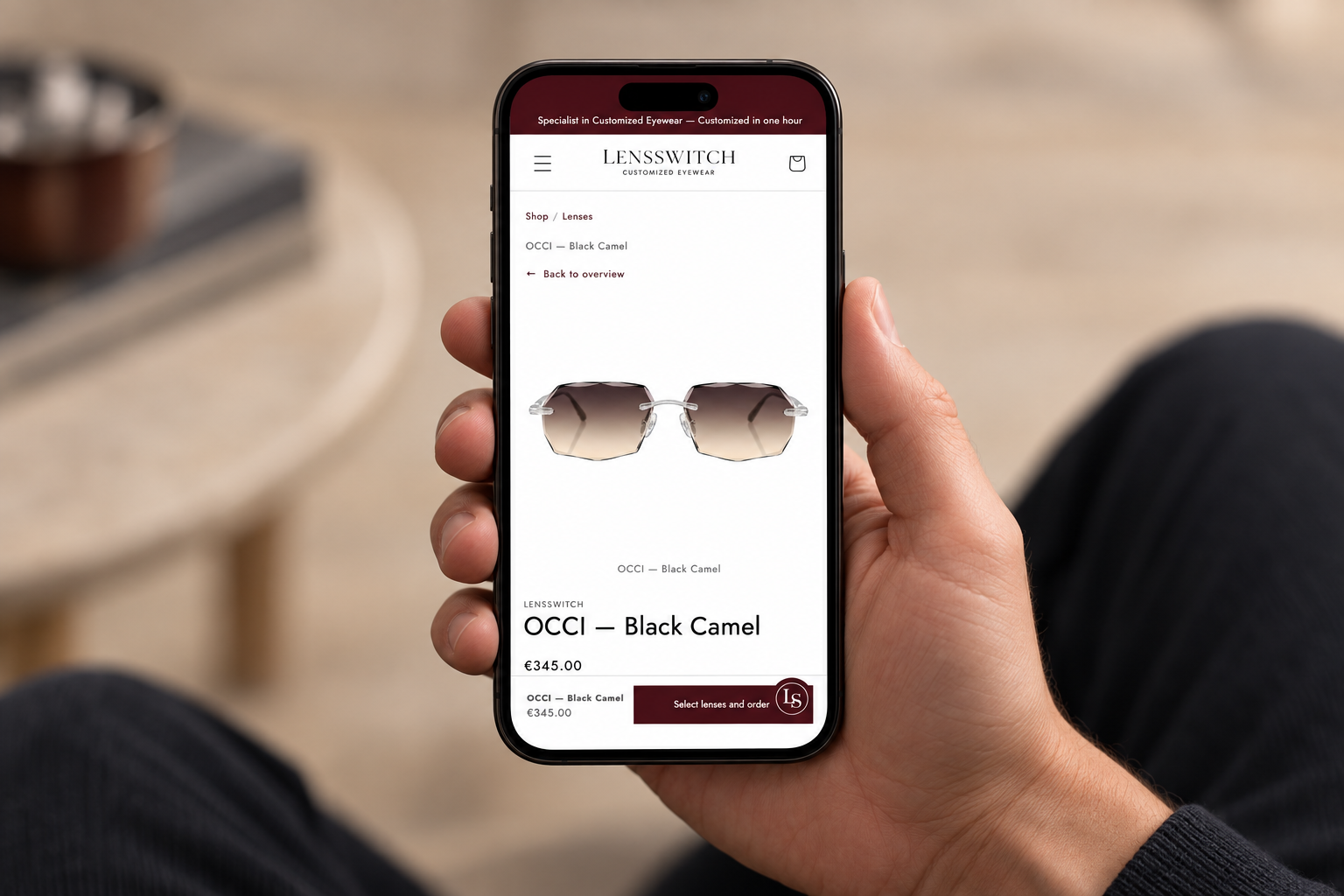 A hand holding a phone displaying the OCCI Black Camel product page